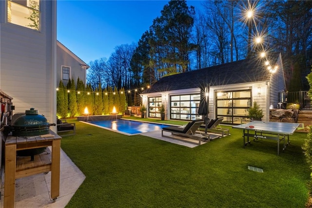 view of swimming pool with an outdoor structure, a lawn, a fenced in pool, and a patio area