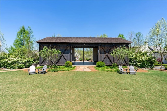 rear view of property with a yard and an outbuilding