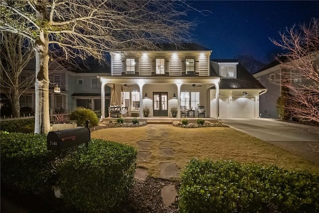 exterior space featuring covered porch, an attached garage, concrete driveway, and french doors