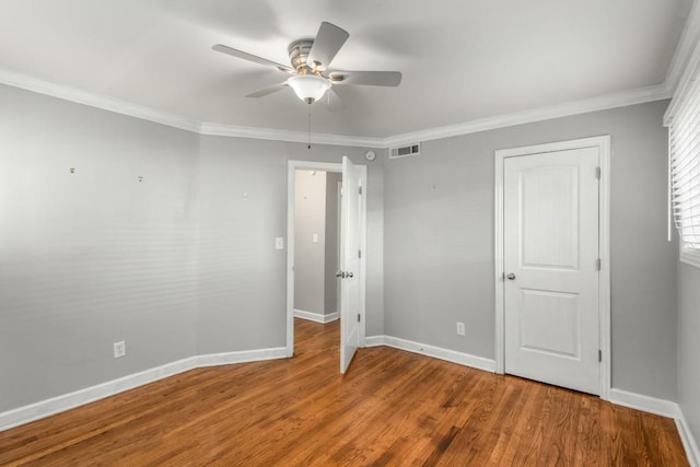 unfurnished bedroom featuring ceiling fan, crown molding, and hardwood / wood-style floors