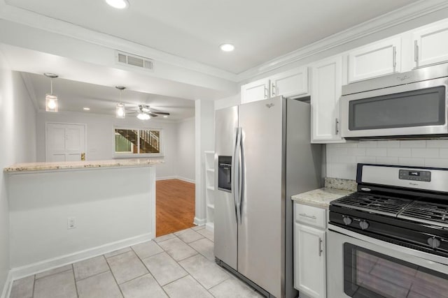 kitchen featuring stainless steel appliances, hanging light fixtures, light tile patterned floors, white cabinets, and backsplash