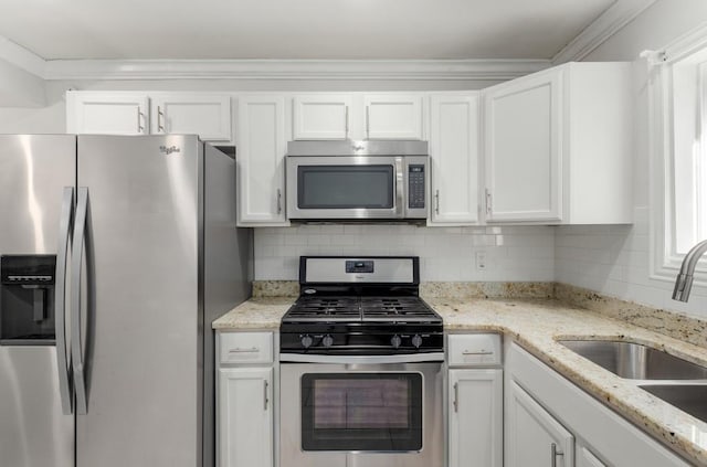 kitchen with appliances with stainless steel finishes, white cabinets, and decorative backsplash