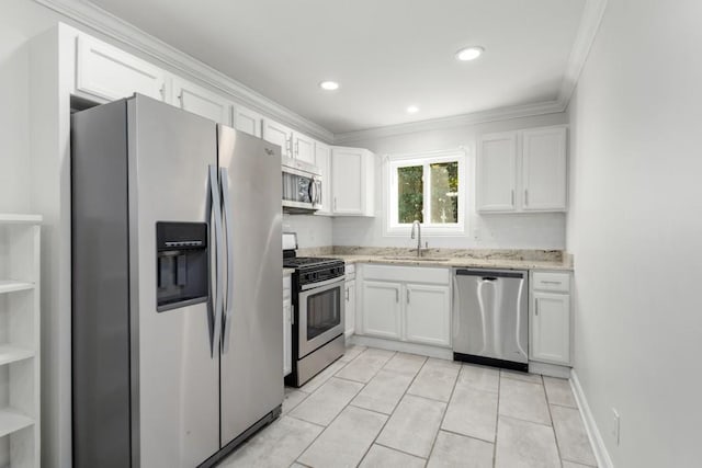 kitchen with sink, white cabinetry, ornamental molding, light tile patterned floors, and appliances with stainless steel finishes