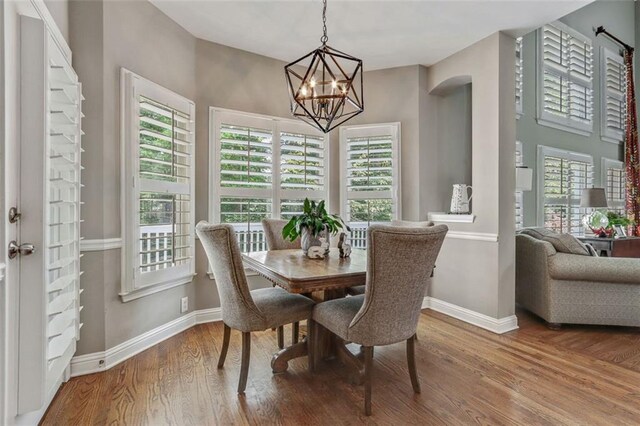 2073 Woodside Park Dr, Woodstock, GA 30188 - dining area featuring a chandelier, wood finished floors, and arched walkways