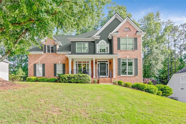 2073 Woodside Park Dr, Woodstock, GA 30188 - view of front facade with brick siding, a front lawn, and covered porch