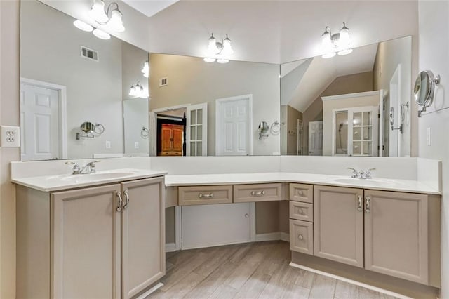 2073 Woodside Park Dr, Woodstock, GA 30188 - full bathroom with two vanities, wood finished floors, and high vaulted ceiling