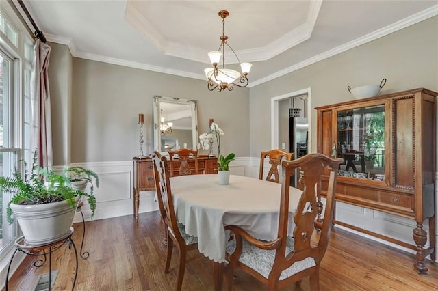 2073 Woodside Park Dr, Woodstock, GA 30188 - dining area with wood finished floors, a chandelier, a wainscoted wall, a raised ceiling, and crown molding
