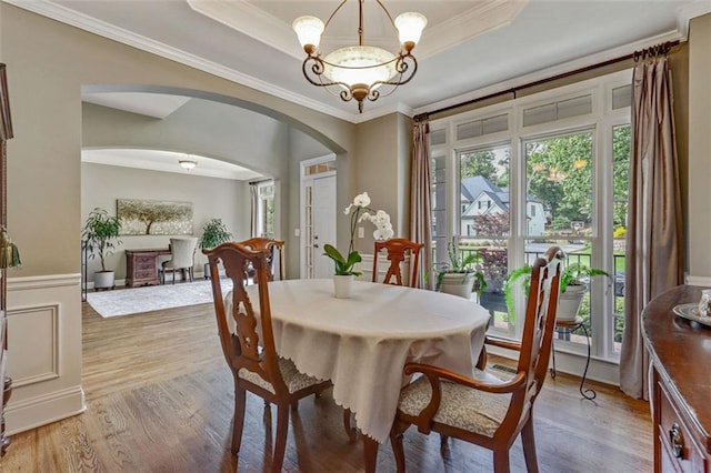 2073 Woodside Park Dr, Woodstock, GA 30188 - dining space featuring arched walkways, plenty of natural light, light wood-style flooring, a chandelier, and ornamental molding