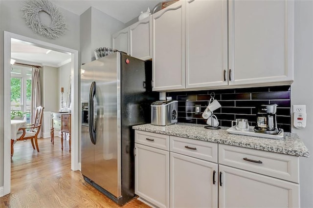 2073 Woodside Park Dr, Woodstock, GA 30188 - kitchen with stainless steel refrigerator with ice dispenser, light wood finished floors, backsplash, white cabinetry, and light stone counters