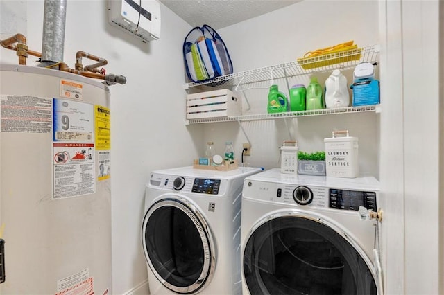 washroom featuring a textured ceiling, laundry area, gas water heater, and washing machine and clothes dryer