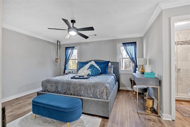 bedroom with baseboards, visible vents, multiple windows, and wood finished floors