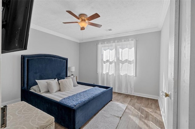 bedroom with crown molding, visible vents, light wood-style flooring, a textured ceiling, and baseboards