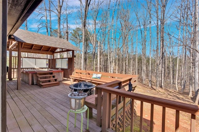 deck featuring a gazebo, an outdoor fire pit, and a hot tub