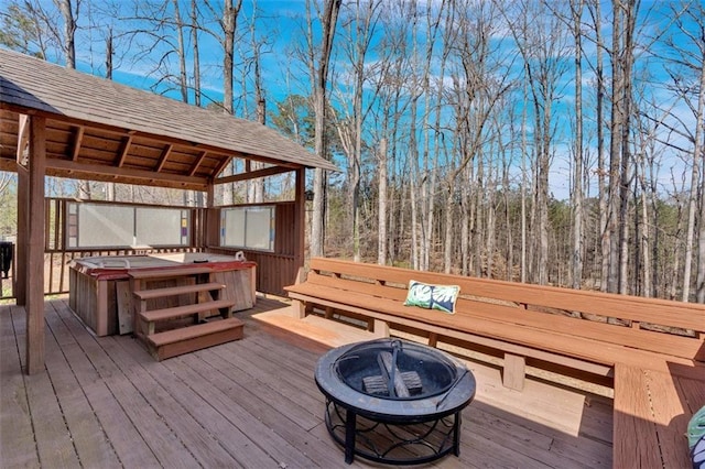 wooden deck with a gazebo, an outdoor fire pit, and a hot tub