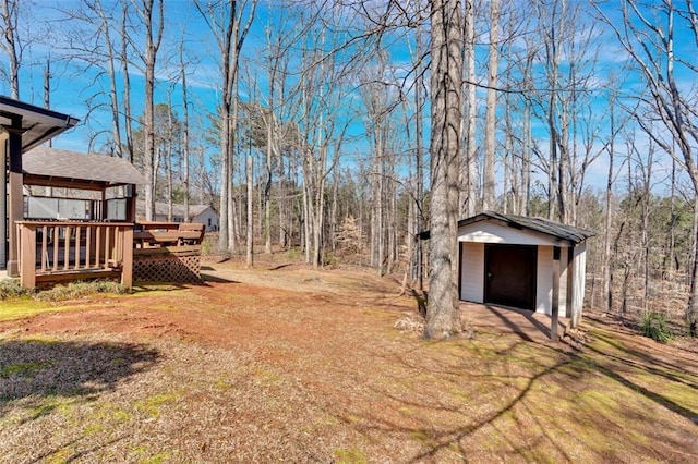 view of yard featuring an outdoor structure and a wooden deck