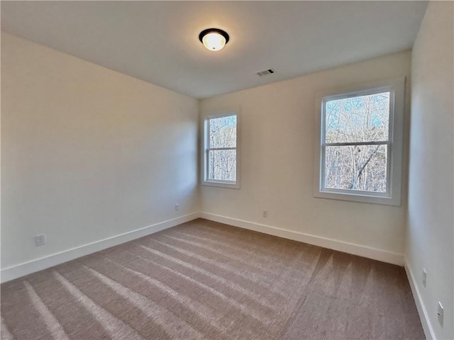 carpeted empty room with visible vents and baseboards