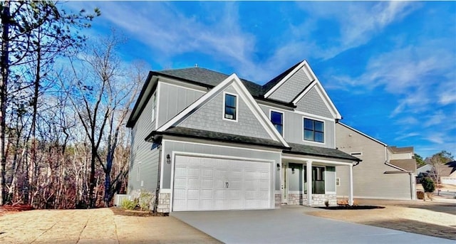 view of front of property with a garage, concrete driveway, and a shingled roof