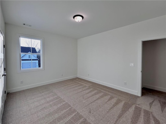 spare room with baseboards, visible vents, and carpet flooring