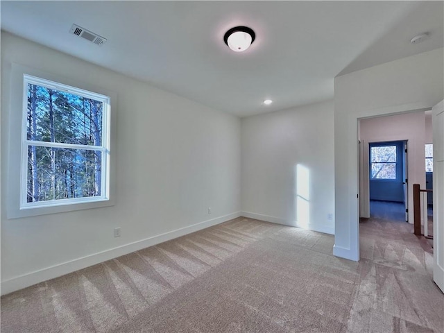 spare room with recessed lighting, visible vents, baseboards, and light colored carpet