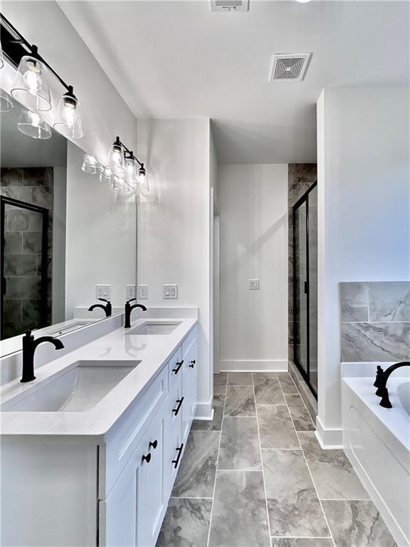 bathroom featuring double vanity, visible vents, a sink, a shower stall, and a bath