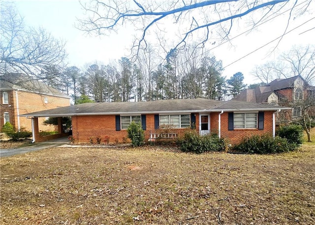 ranch-style home with driveway, a carport, and brick siding