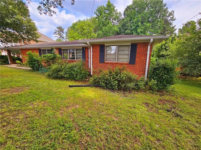 view of front facade with a front yard and brick siding