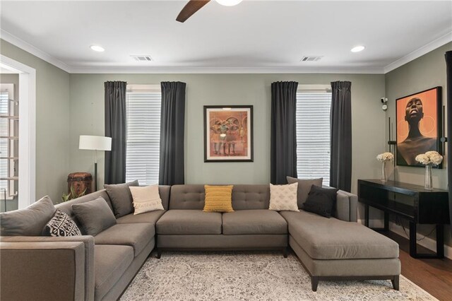 living room with ceiling fan, ornamental molding, and light wood-type flooring