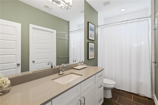 bathroom with vanity, curtained shower, and toilet