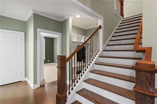 stairs featuring ornamental molding and hardwood / wood-style flooring