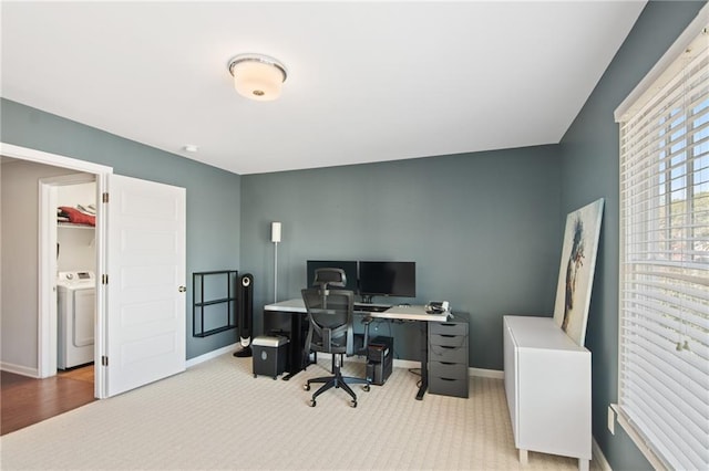 office area with washer / dryer and light colored carpet