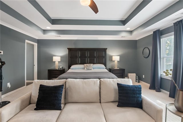 carpeted bedroom featuring ornamental molding, a raised ceiling, and ceiling fan