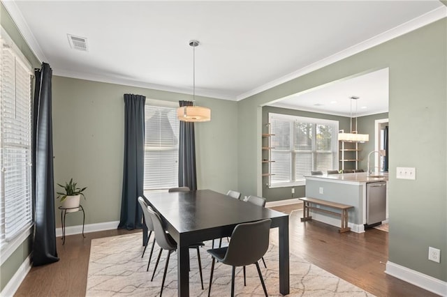 dining area featuring ornamental molding and hardwood / wood-style flooring