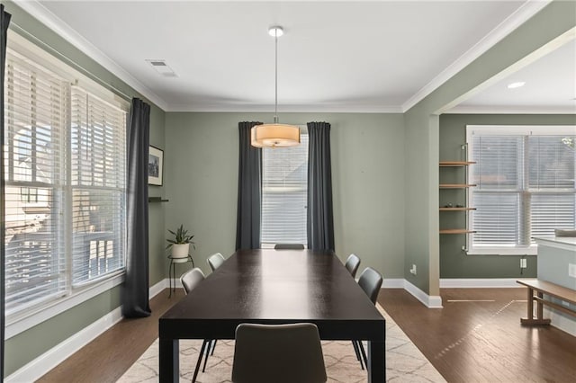 dining area featuring wood-type flooring and ornamental molding