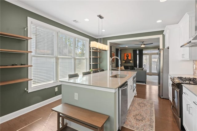 kitchen with a kitchen island with sink, hanging light fixtures, stainless steel appliances, and white cabinets