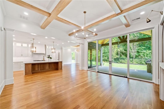 115 Baxley Ln, Alpharetta, GA 30004 - unfurnished living room with visible vents, light wood-type flooring, an inviting chandelier, and coffered ceiling