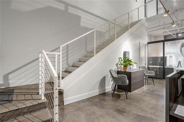 staircase with concrete floors and baseboards