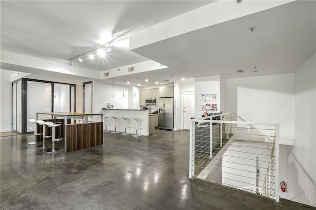 kitchen with visible vents, concrete floors, a breakfast bar area, recessed lighting, and stainless steel appliances