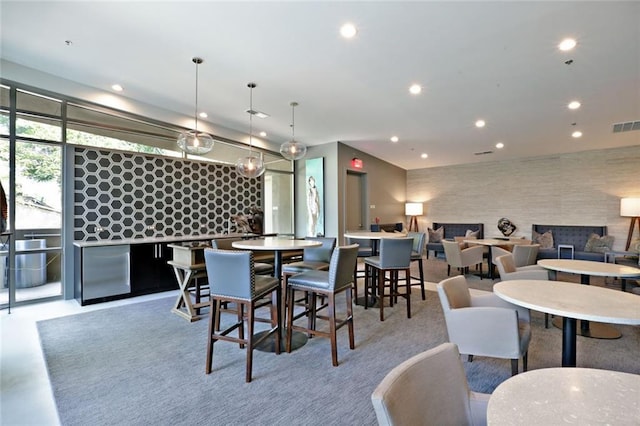dining space featuring an accent wall, finished concrete flooring, recessed lighting, and visible vents