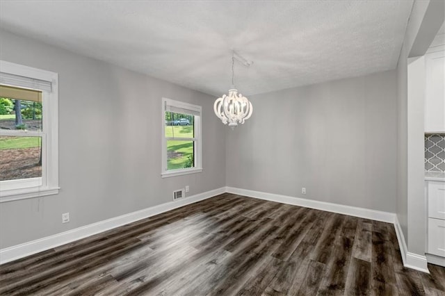 71 Seminole Trl SW, Cartersville, GA 30120 - unfurnished dining area featuring dark wood-style flooring, a chandelier, baseboards, and a textured ceiling