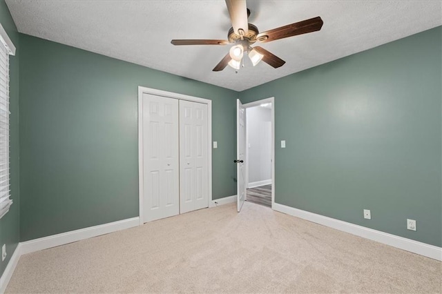 71 Seminole Trl SW, Cartersville, GA 30120 - unfurnished bedroom featuring light colored carpet, a closet, baseboards, a ceiling fan, and a textured ceiling