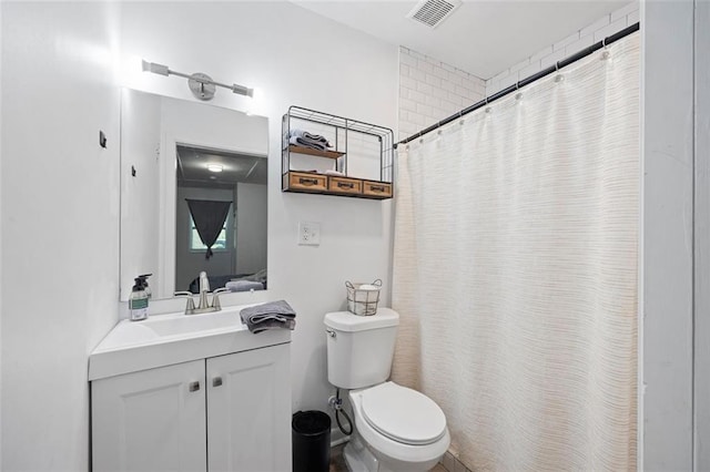 bathroom with curtained shower, vanity, and toilet