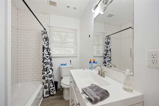 full bathroom with hardwood / wood-style floors, vanity, toilet, and shower / bath combination with curtain