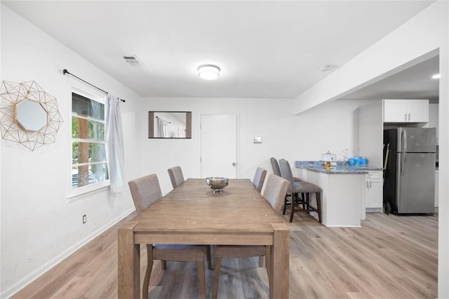 dining space with light wood-type flooring