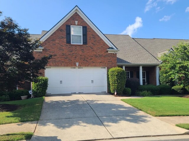 view of property featuring a garage and a front lawn