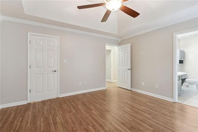 unfurnished bedroom with hardwood / wood-style floors, ornamental molding, ensuite bath, and ceiling fan