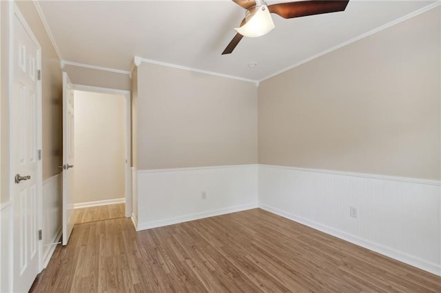 empty room featuring ceiling fan, light wood-type flooring, and ornamental molding