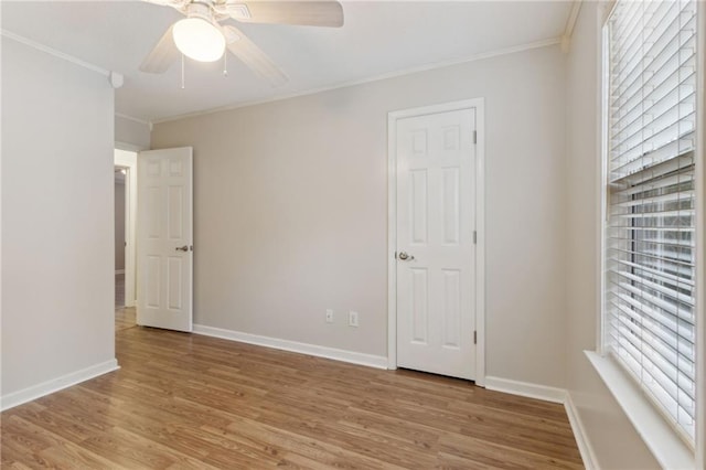 empty room featuring crown molding, light hardwood / wood-style floors, ceiling fan, and plenty of natural light