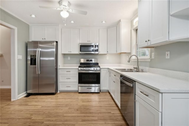 kitchen featuring light hardwood / wood-style floors, sink, white cabinets, appliances with stainless steel finishes, and ceiling fan