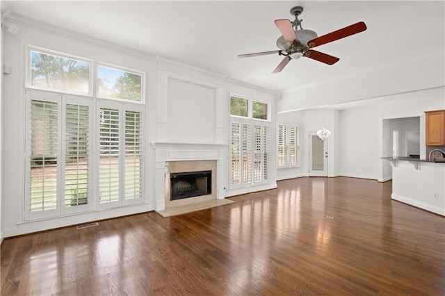 5725 Lake Oak Lndg, Cumming, GA 30040 - unfurnished living room featuring a fireplace with flush hearth, plenty of natural light, a ceiling fan, dark wood-style floors, and ornamental molding