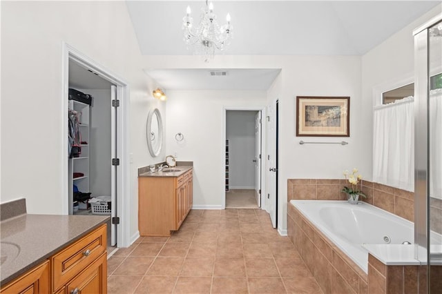 5725 Lake Oak Lndg, Cumming, GA 30040 - bathroom featuring two vanities, a jetted tub, a chandelier, a walk in closet, and lofted ceiling
